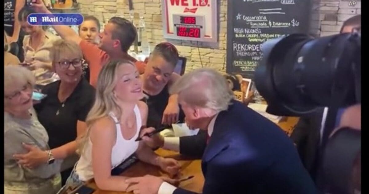 WATCH: President Trump Makes Surprise Appearance at Crowded Iowa Pub After Campaign Speeches - Signs Beaming Young Woman's Top and Dishes Out Pizzas While Massive Crowd Cheers | The Gateway Pundit