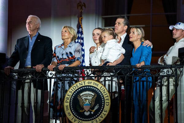 President Biden, Jill Biden and Hunter Biden stand on a balcony of the White House watching fireworks with other members of their family.
